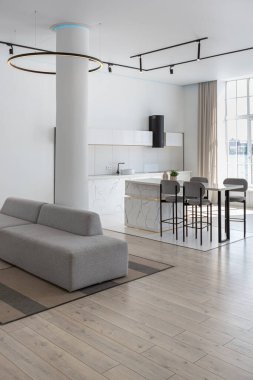 Güneşli bir günde mermer süslemeli pahalı bir evin minimalist modern lüks tasarımı. Alçılı beyaz duvarlar, parke, dekoratif ışıklandırma ve içeride kimse yok.