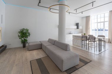 Güneşli bir günde mermer süslemeli pahalı bir evin minimalist modern lüks tasarımı. Alçılı beyaz duvarlar, parke, dekoratif ışıklandırma ve içeride kimse yok.