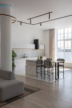 Güneşli bir günde mermer süslemeli pahalı bir evin minimalist modern lüks tasarımı. Alçılı beyaz duvarlar, parke, dekoratif ışıklandırma ve içeride kimse yok.