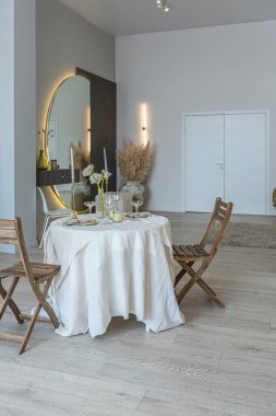 Romantik masa, aydınlık duvarları ve ahşap zemini olan, modern tarzda, açık planlı bir dairede, mutfakta iki kişilik servis edilir..