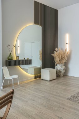 Modern bir tasarım içinde parlak, açık planlı bir daire, aydınlık duvarlar ve gün ışığının olduğu bir odada ahşap zemin.