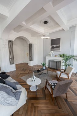 Pahalı, parlak bir iç mekan tarihi bir malikanede büyük bir oturma odası kemerli kemerler, sütunlar ve süslemelerle süslenmiş beyaz duvarlar..