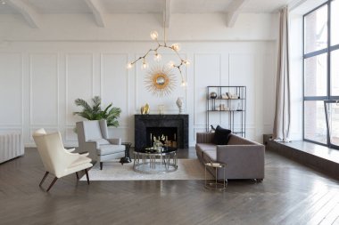 Pastel renklerde modern lüks daireler. Gün ışığıyla dolu kocaman pencereli çok parlak bir oda. Beyaz duvarlar, ahşap parke döşemeler ve koyu mermer bir şömine.