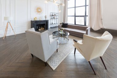 Pastel renklerde modern lüks daireler. Gün ışığıyla dolu kocaman pencereli çok parlak bir oda. Beyaz duvarlar, ahşap parke döşemeler ve koyu mermer bir şömine.