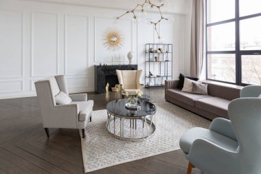 Pastel renklerde modern lüks daireler. Gün ışığıyla dolu kocaman pencereli çok parlak bir oda. Beyaz duvarlar, ahşap parke döşemeler ve koyu mermer bir şömine.