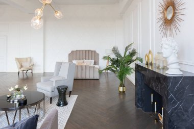 Pastel renklerde modern lüks daireler. Gün ışığıyla dolu kocaman pencereli çok parlak bir oda. Beyaz duvarlar, ahşap parke döşemeler ve koyu mermer bir şömine.