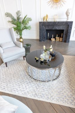 Pastel renklerde modern lüks daireler. Gün ışığıyla dolu kocaman pencereli çok parlak bir oda. Beyaz duvarlar, ahşap parke döşemeler ve koyu mermer bir şömine.