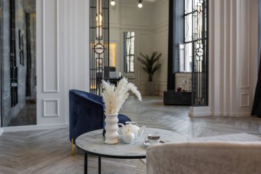 Parlak, lüks bir dağ evi. Kış ormanlarının göz kamaştırıcı manzarası panoramik pencerelerden beyaz duvarlar, süsler, şömine, iş ve gün boyu insan olmadan oturma alanı.