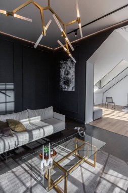 Lüks dairenin, beyaz şık yatak odası ve karanlık oturma odası olan minimalist, şık bir tasarımı var. Gündüz boyunca insansız ve güneş ışınları olmayan modern daireler.