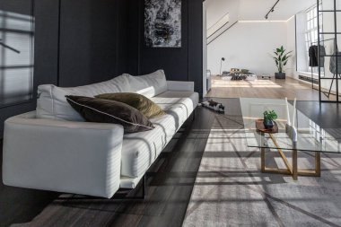 Lüks dairenin, beyaz şık yatak odası ve karanlık oturma odası olan minimalist, şık bir tasarımı var. Gündüz boyunca insansız ve güneş ışınları olmayan modern daireler.