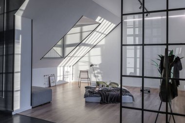 Lüks dairenin, beyaz şık yatak odası ve karanlık oturma odası olan minimalist, şık bir tasarımı var. Gündüz boyunca insansız ve güneş ışınları olmayan modern daireler.