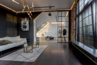 Lüks dairenin, beyaz şık yatak odası ve karanlık oturma odası olan minimalist, şık bir tasarımı var. Gündüz boyunca insansız ve güneş ışınları olmayan modern daireler.