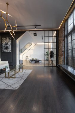 Lüks dairenin, beyaz şık yatak odası ve karanlık oturma odası olan minimalist, şık bir tasarımı var. Gündüz boyunca insansız ve güneş ışınları olmayan modern daireler.