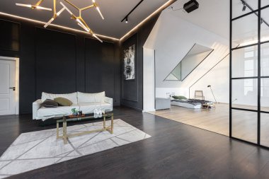 Lüks dairenin, beyaz şık yatak odası ve karanlık oturma odası olan minimalist, şık bir tasarımı var. Gündüz boyunca insansız ve güneş ışınları olmayan modern daireler.