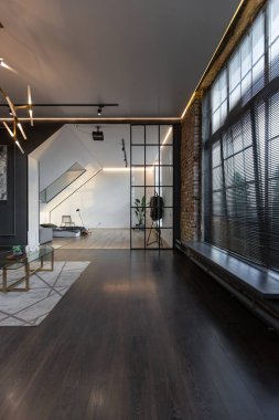 Lüks dairenin, beyaz şık yatak odası ve karanlık oturma odası olan minimalist, şık bir tasarımı var. Gündüz boyunca insansız ve güneş ışınları olmayan modern daireler.