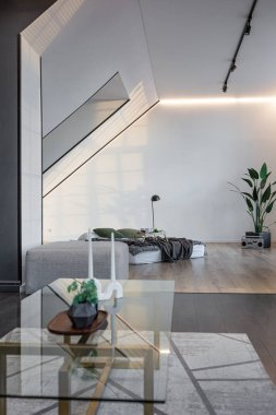 Lüks dairenin, beyaz şık yatak odası ve karanlık oturma odası olan minimalist, şık bir tasarımı var. Gündüz boyunca insansız ve güneş ışınları olmayan modern daireler.