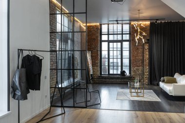 Lüks dairenin, beyaz şık yatak odası ve karanlık oturma odası olan minimalist, şık bir tasarımı var. Gündüz boyunca insansız ve güneş ışınları olmayan modern daireler.