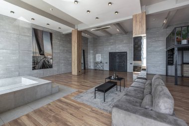 İki katlı bir dairenin modern iç dekorasyonunda gündüz vakti gri tonlarda tavan arası tarzı insanlar yok..