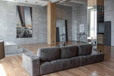 Süslü minimalist dizginlenmiş modern apartman dairesi, yüzme havuzlu geniş bir oda, dağlara bakan geniş panoramik pencereler. Gündüzleri insanlar olmadan