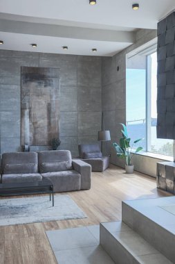 Süslü minimalist dizginlenmiş modern apartman dairesi, yüzme havuzlu geniş bir oda, dağlara bakan geniş panoramik pencereler. Gündüzleri insanlar olmadan