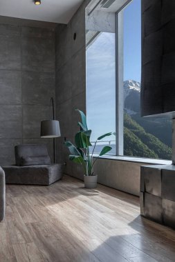 Süslü minimalist dizginlenmiş modern apartman dairesi, yüzme havuzlu geniş bir oda, dağlara bakan geniş panoramik pencereler. Gündüzleri insanlar olmadan