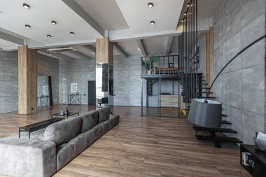 İki katlı bir dairenin modern iç dekorasyonunda gündüz vakti gri tonlarda tavan arası tarzı insanlar yok..