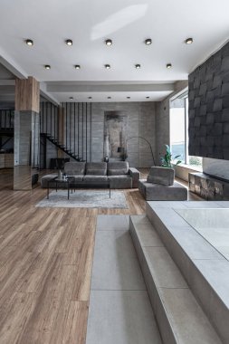 Süslü minimalist dizginlenmiş modern apartman dairesi, yüzme havuzlu geniş bir oda, dağlara bakan geniş panoramik pencereler. Gündüzleri insanlar olmadan