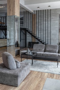İki katlı bir dairenin modern iç dekorasyonunda gündüz vakti gri tonlarda tavan arası tarzı insanlar yok..