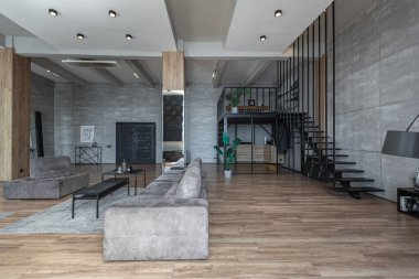 İki katlı bir dairenin modern iç dekorasyonunda gündüz vakti gri tonlarda tavan arası tarzı insanlar yok..