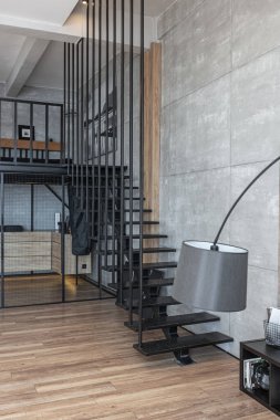 İki katlı bir dairenin modern iç dekorasyonunda gündüz vakti gri tonlarda tavan arası tarzı insanlar yok..