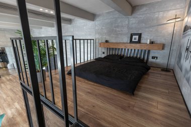 İki katlı bir dairenin modern iç dekorasyonunda gündüz vakti gri tonlarda tavan arası tarzı insanlar yok..