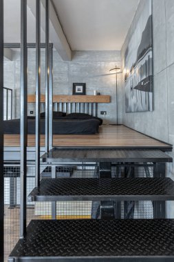 İki katlı bir dairenin modern iç dekorasyonunda gündüz vakti gri tonlarda tavan arası tarzı insanlar yok..