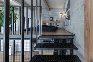 İki katlı bir dairenin modern iç dekorasyonunda gündüz vakti gri tonlarda tavan arası tarzı insanlar yok..