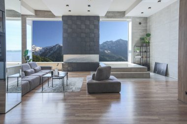 Süslü minimalist dizginlenmiş modern apartman dairesi, yüzme havuzlu geniş bir oda, dağlara bakan geniş panoramik pencereler. Gündüzleri insanlar olmadan