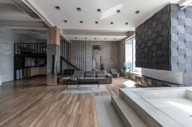 Süslü minimalist dizginlenmiş modern apartman dairesi, yüzme havuzlu geniş bir oda, dağlara bakan geniş panoramik pencereler. Gündüzleri insanlar olmadan