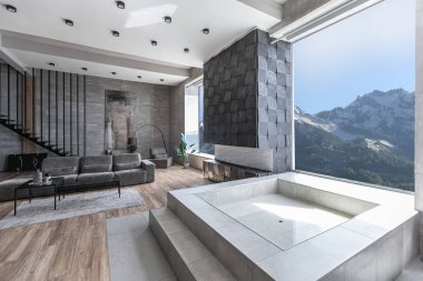 Süslü minimalist dizginlenmiş modern apartman dairesi, yüzme havuzlu geniş bir oda, dağlara bakan geniş panoramik pencereler. Gündüzleri insanlar olmadan