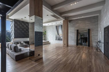 Süslü minimalist dizginlenmiş modern apartman dairesi, yüzme havuzlu geniş bir oda, dağlara bakan geniş panoramik pencereler. Gündüzleri insanlar olmadan