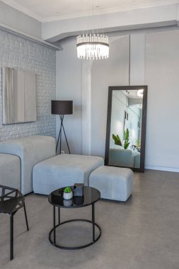 Modern bir stüdyoda, yeşil bitkilerle beyaz-gri renkli şık bir iç mekan. Gün ışığı ve içeride kimse yok.