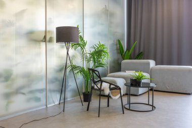 Arkasında bitkilerin bulunduğu şeffaf tasarımcı bölümünün arka planına karşı masa ve sandalyeyle muhteşem bir alan.