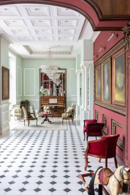 Oturma odasının şaşaalı, tarihi Barok tarzında bir iç mekanı, zeminde fayanslar, ahşap duvarlar. Mobilyaların tarihi bir tarzı var..