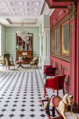 Oturma odasının şaşaalı, tarihi Barok tarzında bir iç mekanı, zeminde fayanslar, ahşap duvarlar. Mobilyaların tarihi bir tarzı var..