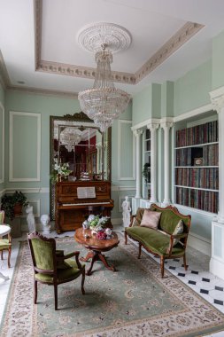 Oturma odasının şaşaalı, tarihi Barok tarzında bir iç mekanı, zeminde fayanslar, ahşap duvarlar. Mobilyaların tarihi bir tarzı var..