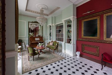 Oturma odasının şaşaalı, tarihi Barok tarzında bir iç mekanı, zeminde fayanslar, ahşap duvarlar. Mobilyaların tarihi bir tarzı var..