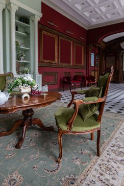 the chic expensive interior of the living room in the historical Baroque style, tiles on the floor, walls decorated with wood. the furniture is in a historical style. clipart