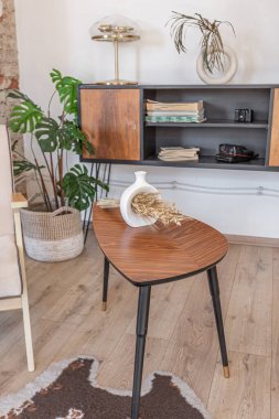 Modern mobilyaların ve doğal ışığın yumuşak sıcak renklerde şık bir dairede bulunduğu parlak ve ferah bir yaşam alanı.