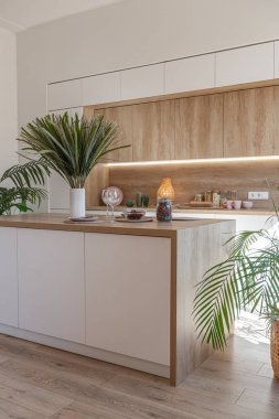 Modern mobilyaların ve doğal ışığın yumuşak sıcak renklerde şık bir dairede bulunduğu parlak ve ferah bir yaşam alanı.