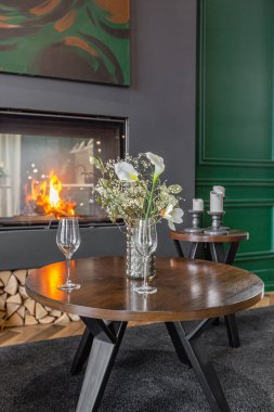 Oturma odasının karanlık, vahşi iç mekanı panoramik pencereli bir malikanede tarihi bir şekilde. Gri yeşil duvarlar, kahverengi parke ve modern mobilyalar..