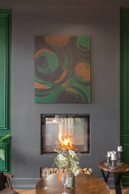 Oturma odasının karanlık, vahşi iç mekanı panoramik pencereli bir malikanede tarihi bir şekilde. Gri yeşil duvarlar, kahverengi parke ve modern mobilyalar..