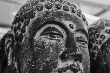 Yakın çekim beton Buda kafası. Modern sanat konsepti. Siyah beyaz fotoğraf, yumuşak odak