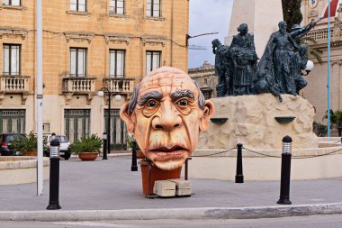 Giant papier-mache heads of carnival dolls decorate the streets during the carnival celebration: Zabbar, Malta - February 27, 2022